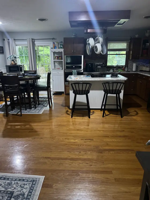 Open kitchen and island over hardwood floors