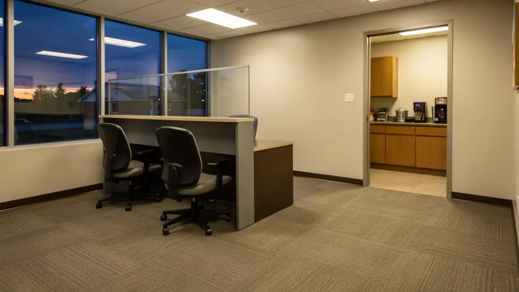 Office reception after an evening clean, desks cleared and vacuum lines in the carpet