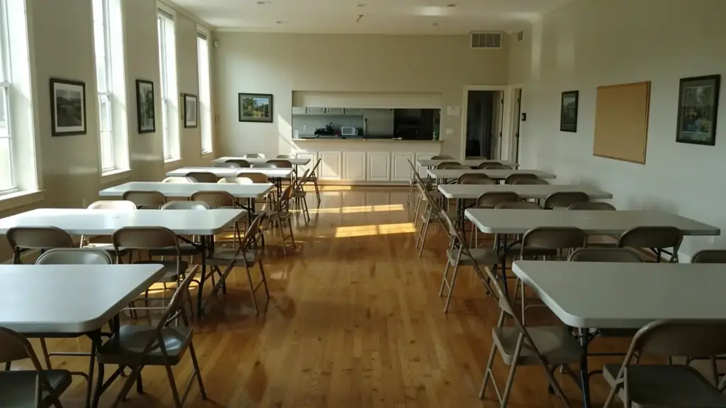 Fellowship hall with tables wiped bare and chairs squared on a polished wood floor